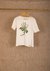 T-shirt em malha 100% algodão orgânico, cor off white natural do tecido. Na parte frontal da blusa está estampado o desenho da planta Artemísia.