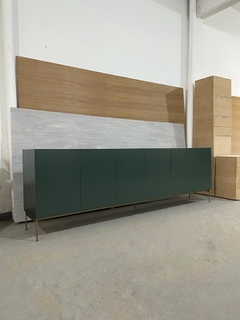 Vista de frente inclinado hacia la derecha del mueble Vajillero color verde, que cuenta con seis puertas, y cinco patas de estructura metálica. 