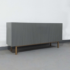Vista de frente inclinado hacia la derecha del mueble Vajillero color gris, que cuenta con cuatro puertas que tienen un calado, y cuatro patas de estructura metálica.