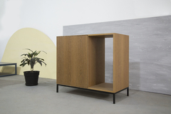 Vista de frente con leve inclinación hacia la izquierda del mueble para cava, color madera petiribi. Posee dos puertas y un hueco para insertar la cava a medida.