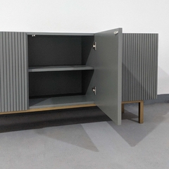 Vista de frente inclinado hacia la derecha del mueble Vajillero color gris, que cuenta con cuatro puertas (una abierta mostrando la profundidad del mueble y el estante interno que tiene) que tienen un calado, y cuatro patas de estructura metálica.