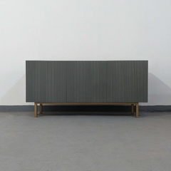 Vista de frente del mueble Vajillero color gris, que cuenta con cuatro puertas que tienen un calado, y cuatro patas de estructura metálica.
