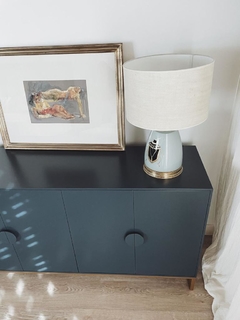Vista superior del mueble Vajillero color azul, donde se aprecia la superficie superior del mueble, que tiene cuatro puertas (la imagen solo comprende tres puertas) con tiradores decorados, y cuatro patas metálicas.