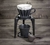 Kit de café individual sobre uma mesa mostrando suporte, coador 100 com filtro de pano e copo. Todos na cor preta.
