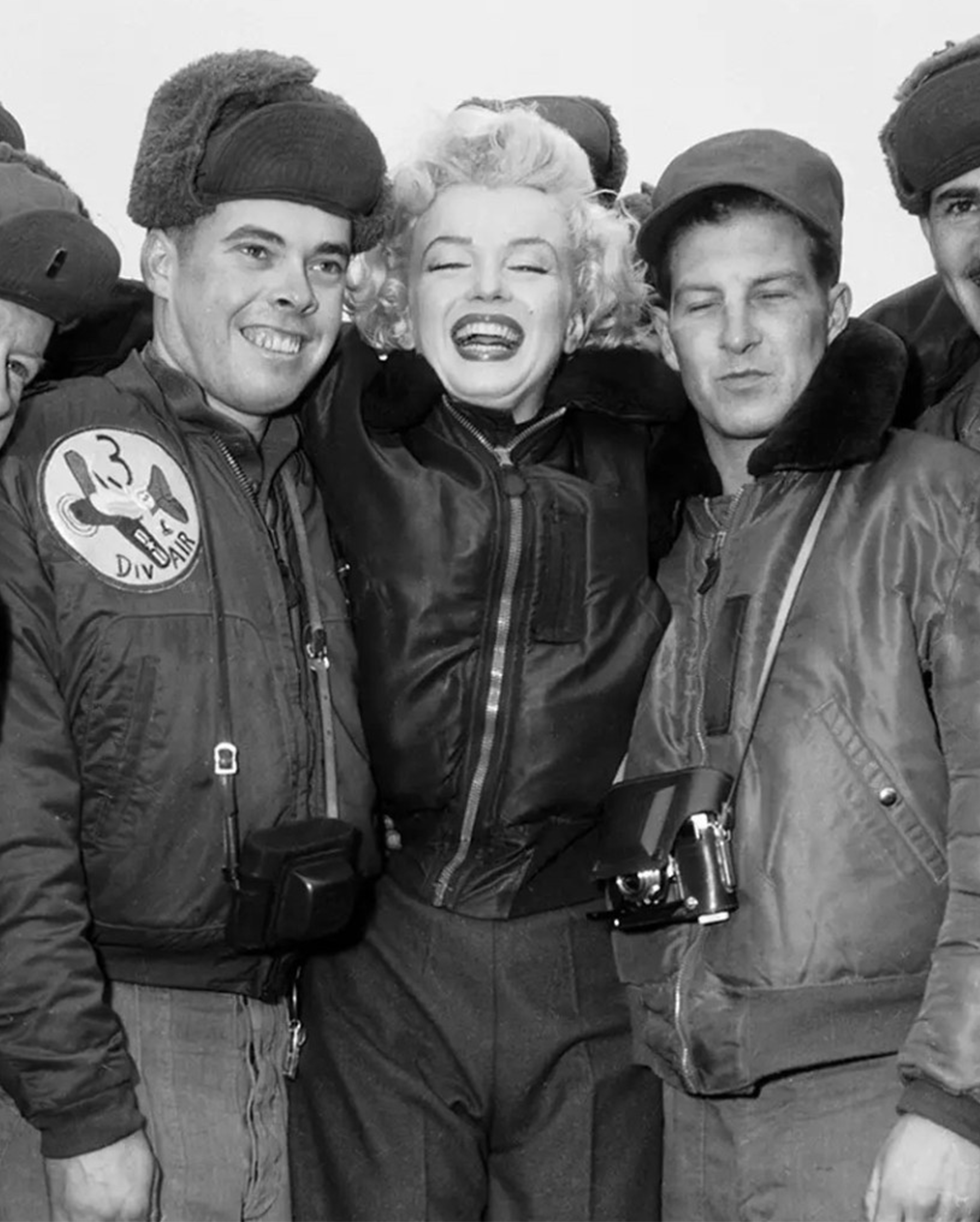 Marylin Monroe junto com combatentes vestindo uma jaqueta bomber b-15