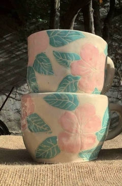 Taza con flores rosas y hojas verdes