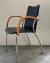 (LP) 6 sillas c/ patas cromadas, tapizadas en ecocuero negro c/ apoyabrazos de madera. Sin uso. / 57 x 37 x 45/82