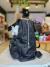 MOCHILA TELA DE AVION NEGRA Y PLATEADA en internet