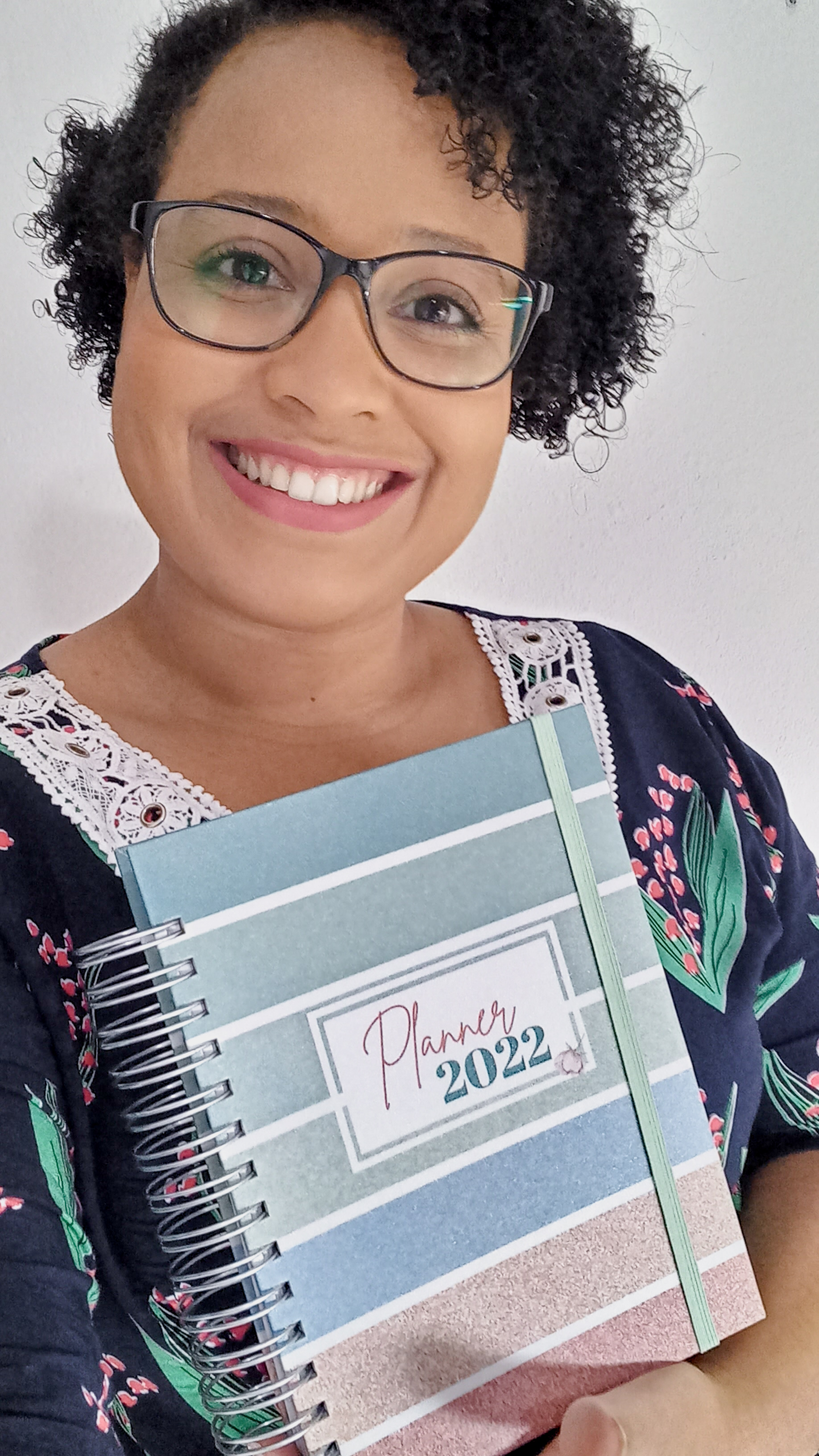 Foto que mostra a proprietária da Lizelan, Jessica Marciano segurando um caderno com a capa que diz Planner 2022
