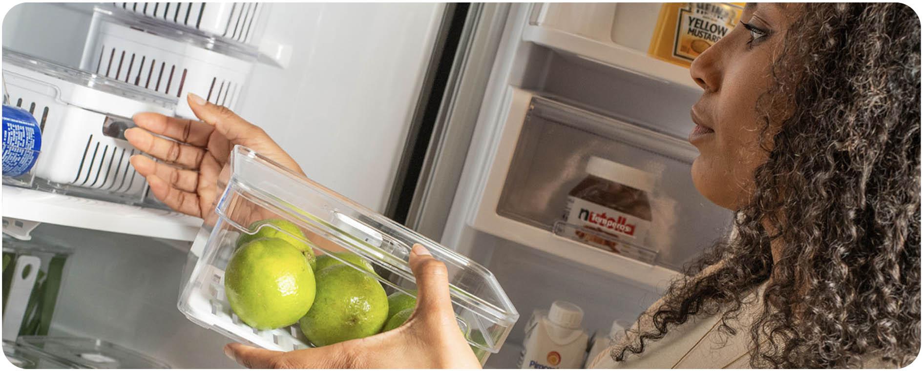 Mulher colocando Organizador de Geladeira 2,2L na Geladeira