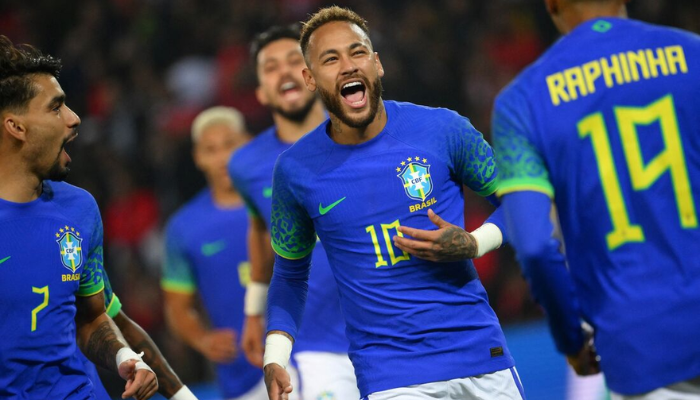 Camisa Reserva da Seleção Brasileira Nike 2022-2023 em azul com detalhes em verde, estampa de onça-pintada nas mangas, Swoosh verde, escudo da CBF, selo “Garra Brasileira” e bandeira nacional estilizada.