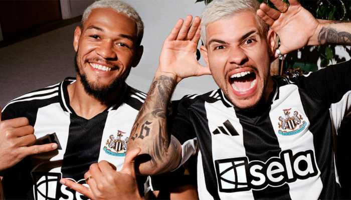 Camisa titular do Newcastle United 2024-25 com listras verticais em preto e branco, gola V preta, detalhes em preto nos ombros e mangas, escudo do NUFC no lado esquerdo do peito, logo da Adidas em preto no lado direito, patrocínio da Sela em branco com borda preta, patrocinador de manga em amarelo, escudo antigo do clube nas costas.