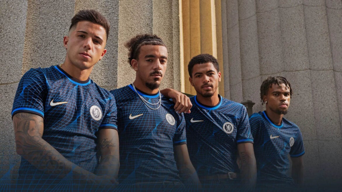 Camisa Reserva Chelsea FC 2023/24 em azul marinho com padrão de diamantes entrelaçados, gola redonda e escudo do Chelsea. Um tributo à história do clube | Tevo Sports