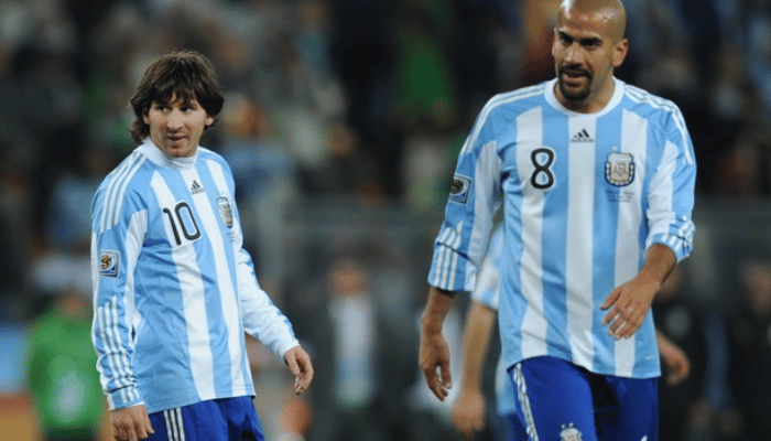 camisa titular da seleção argentina de futebol, utilizada na Copa do Mundo de 2010. A camisa é predominantemente branca com listras horizontais em azul celeste. O escudo da AFA está bordado no lado esquerdo do peito, enquanto o logo da Adidas está aplicado em azul celeste no lado direito. O número 10 e o nome "Messi" estão estampados nas costas da camisa.