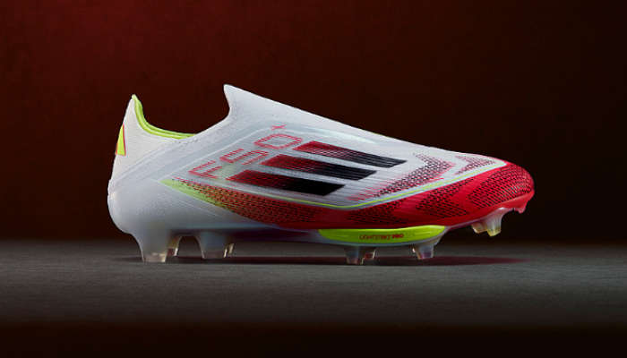 chuteira de campo adidas F50 Elite FG Plus Pure Victory FG em branco, rosa e amarelo. A chuteira tem um design moderno com um cabedal de material sintético e um solado com cravos moldados.  A chuteira está posicionada de lado, mostrando os detalhes do cadarço integrado e do tornozelo acolchoado.