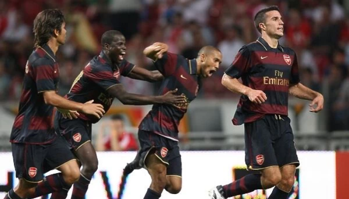 A camisa retro do Arsenal da temporada 2007-2008, nas cores grená, azul marinho e dourado. A peça homenageia a era pós-Thierry Henry, com Emmanuel Adebayor assumindo o protagonismo. 