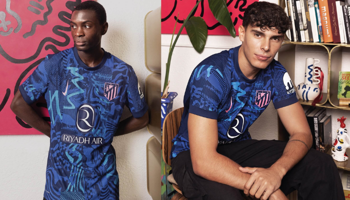 Terceira Camisa do Atlético de Madrid 2024/2025: azul marinho com grafismo vibrante. Destaques incluem o tridente de Netuno, Nike Swoosh rosa e escudo do Atleti em azul e rosa.