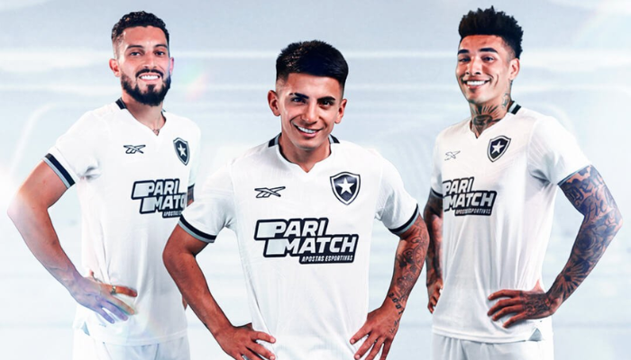 nova camisa alternativa do Botafogo para a temporada 2024/2025. A camisa branca possui um design futurista com uma mandala central e detalhes em preto e prata. 