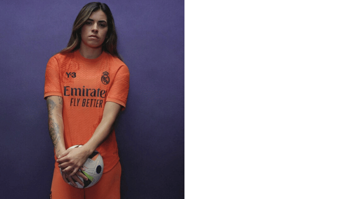 Camisa laranja de goleiro do Real Madrid 2024/25 da Y-3. Possui gola redonda, mangas com recortes laterais, escudo do Real Madrid em branco no lado esquerdo do peito, logo da Y-3 em branco no lado direito do peito, patrocínio da Emirates em branco, e rosa na parte inferior direita das costas.