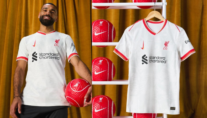 nova camisa alternativa do Liverpool FC para a temporada 2024-2025. A peça, predominantemente branca, possui um design moderno e inovador da Nike, com grafismos em tons de cinza que homenageiam as artistas punk femininas de Liverpool.