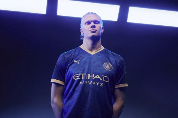 Camisa PUMA Manchester City 2023 Ano-novo Chinês, azul marinho com textura lunar e detalhes dourados, inspirada na canção "Blue Moon". Coordenadas lunares e referências à sonda Chang’e 3.