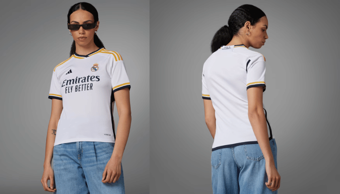 Camisa feminina titular Real Madrid Adidas 2022-2023 branca com gola em V e frisos em azul marinho, branco e dourado. Escudo do Real Madrid à esquerda, logo da Adidas em azul marinho à direita, patrocinador em azul marinho na barra, painéis e faixas laterais, frase "¡Hala Madrid!" em azul marinho na nuca e nomes e numeração dos jogadores em azul marinho.