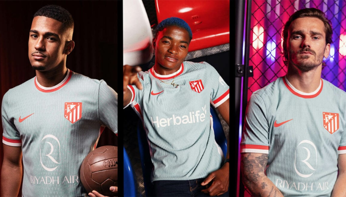 Camisa reserva do Atlético de Madrid Nike 2024-2025. A imagem mostra a camisa azul oceano com detalhes em vermelho e branco, como a gola redonda, os punhos e as laterais. O escudo do Atlético de Madrid está no lado esquerdo do peito e o logo da Nike no lado direito.