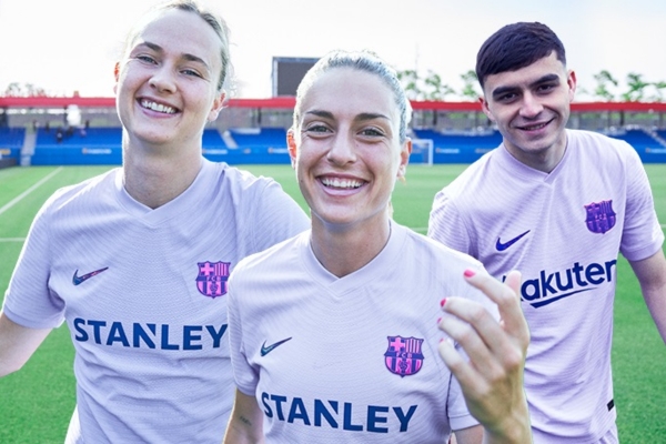 Camisa Reserva Barcelona 2021-2022: Design lilás, faixas dinâmicas vermelhas e azuis, gola V única. Logos Rakuten e Stanley.