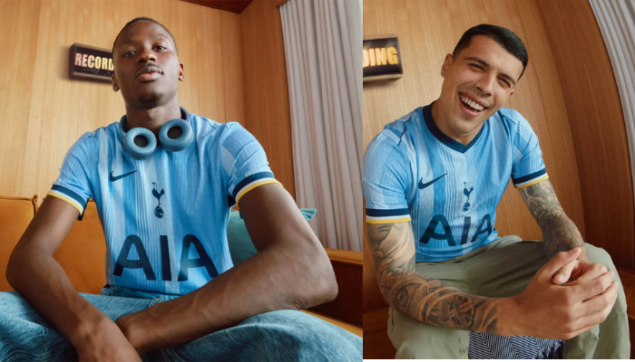 Camisa Reserva Nike Tottenham 2024-2025 azul clara com faixas e listras verticais em tons mais escuros. Gola V em azul marinho, punhos em azul marinho, amarelo e branco. Escudo do Tottenham no peito, logo da Nike no lado direito, patrocínio, nome e número em azul marinho.