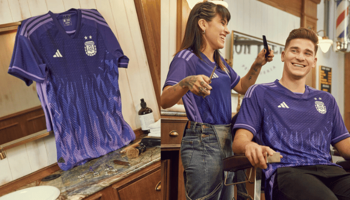 camisa reserva da seleção argentina Adidas 2022-2023 na cor lilás. A camisa apresenta um design vibrante em tons de lilás e roxo, com detalhes em prata. O escudo da AFA e o logo da Adidas ostentam a cor prata, enquanto as tradicionais três listras percorrem os ombros e as laterais do kit.