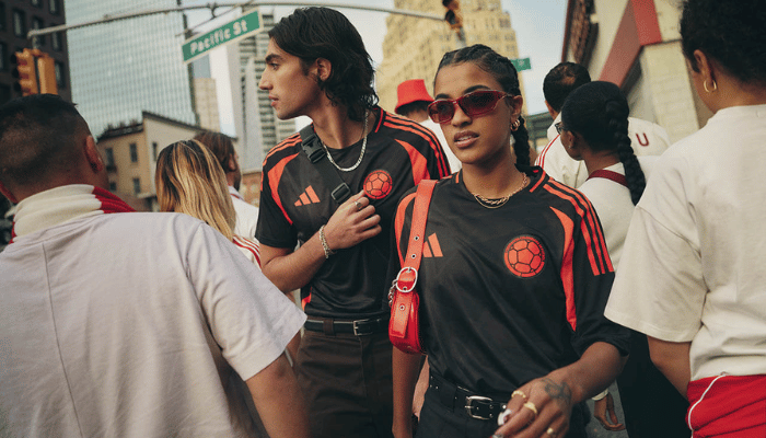 Camisa preta com detalhes em laranja da Seleção Colombiana. As faixas gráficas no corpo da camisa representam os ventos que impulsionam a equipe, enquanto o laranja nas laterais, axilas e mangas evoca o fogo da paixão colombiana.