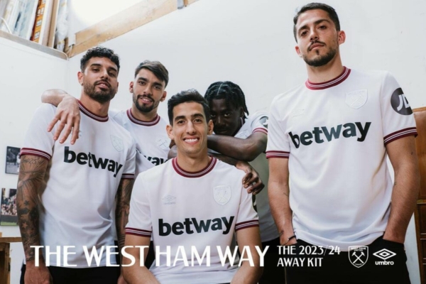 Camisa Reserva West Ham Umbro 2023/24 Masculina Branca e Vinho com detalhes em azul celeste. Martelos cruzados na nuca. Logo e escudo iridescentes. Patrocínios Betway e JD em destaque.