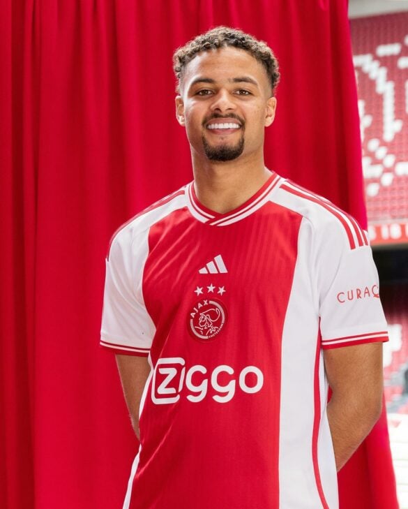 Camisa Titular do Ajax 2023/24 Masculina Vermelha  apresenta a icônica faixa vermelha na vertical, agora ainda maior e com um padrão gráfico listrado na região frontal. As faixas laterais se juntam na barra traseira, acompanhadas pelas três listras nas mangas, gola e punhos | Tevo Sports