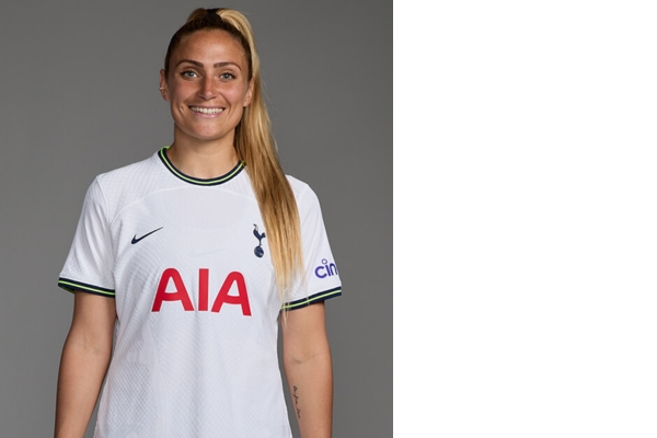 Camisa Titular Feminina do Tottenham Nike 2022/23 em branco puro com detalhes em azul marinho e verde neon. Tecido em relevo, faixas laterais, gola redonda, punhos marcantes, Swoosh azul marinho e escudo Tottenham.