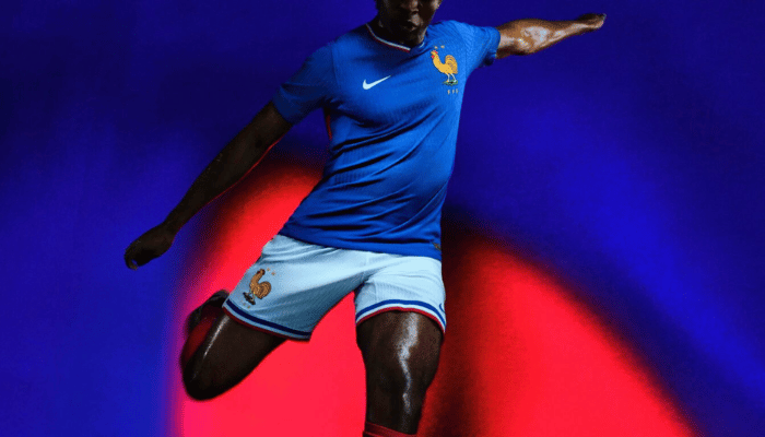 Camisa titular da seleção francesa de futebol 2024-2025. Camisa na cor azul royal com gola V tricolor e o galo, símbolo da seleção, em tamanho maior que o convencional. Na parte interna da gola, a frase "Nos différences nous unissent" (Nossas diferenças nos unem).