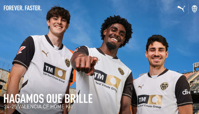 camisa titular do Valencia CF para a temporada 2024-2025, produzida pela Puma. A camisa é predominantemente branca com mangas pretas clássicas adornadas com frisos dourados nos punhos. A gola preta ecoa o estilo retrô, enquanto o escudo do clube é aplicado em dourado e preto no lado esquerdo do peito. 