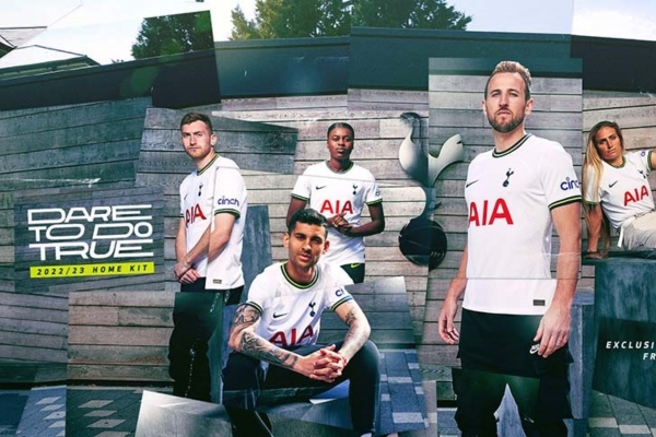 Camisa titular do Tottenham Nike 2022/23 masculina, predominância de branco com detalhes em azul marinho e verde neon. Gola redonda, punhos vibrantes, tecido em relevo e faixas laterais. Swoosh azul no peito direito e escudo Tottenham no esquerdo.