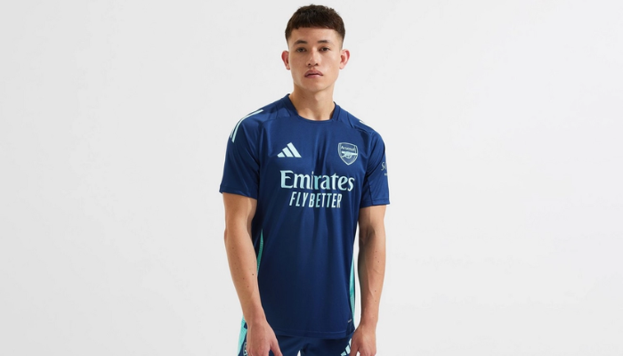 Camisa de treino oficial do Arsenal FC para a temporada 2024-2025. Confeccionada pela Adidas, apresenta as cores azul marinho e verde água, com o logo do clube aplicado em destaque. Possui design moderno, caimento slim e tecnologia AEROREADY para máximo conforto e desempenho durante os treinos.