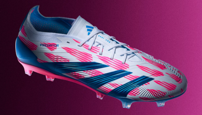 Chuteira de futebol Adidas Predator 24 Corte Baixo FG do Pacote Reemergence em destaque. Apresenta design branco com detalhes em azul e rosa, cabedal branco com padrão de pontos rosa, logo Adidas azul, três listras Adidas azuis, sola azul com detalhes em rosa e travas pretas.