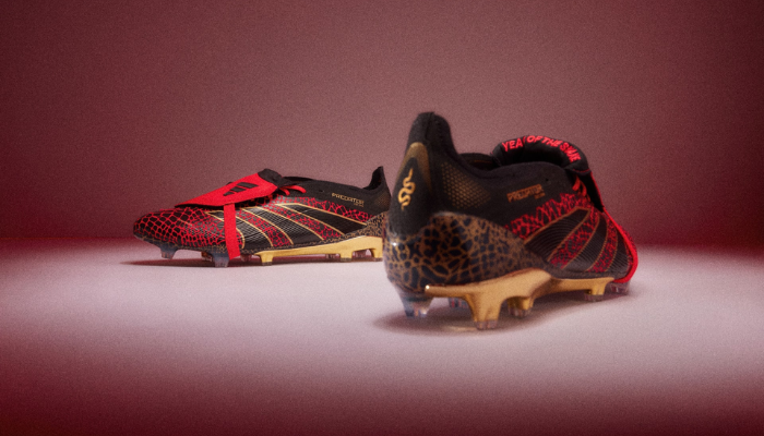 Chuteira de Campo Adidas Predator Year of the Snake FG, edição especial do Ano Novo Chinês, em vermelho vívido, dourado metálico e preto, com gráficos de cobra na palmilha e no calcanhar. Design luxuoso, material HybridTouch