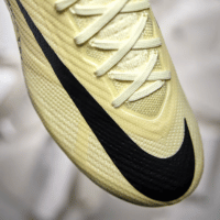 Chuteira Nike Air Zoom Mercurial Vapor 15 FG Mad Ready na deslumbrante cor Lemonade/Black. Projetada para proporcionar máximo desempenho no futebol, esta obra-prima apresenta tecnologia Zoom Air, cabedal Vaporposite+ otimizado para velocidade e forro Speed Cage para suporte leve. Experimente o toque natural da bola com a textura chevron na camada externa.