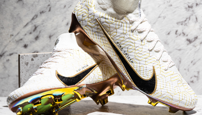 Chuteira Nike Mercurial Superfly 9 Elite FG United Golden na cor branco/dourado. A chuteira possui um cabedal em material sintético respirável, forro em tecido macio e acolchoado, entressola de espuma Phylon para amortecimento leve e sola de borracha com travas multidirecionais para tração em superfícies firmes. A chuteira é ideal para jogadores de ataque que buscam velocidade, agilidade, controle e conforto.