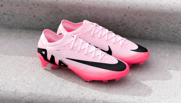 A Chuteira Nike Zoom Mercurial Vapor 15 Elite FG Mad Brilliance em tons de branco, rosa e preto, ostentando o icônico Swoosh em um design metálico e brilhante. A chuteira apresenta uma unidade Zoom Air visível na sola, cabedal texturizado e pitões tri-star para tração multidirecional. Perfeita para jogadores que buscam velocidade, precisão e controle em campo.