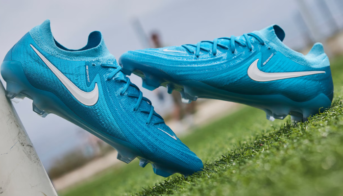 Chuteira de futebol Nike Phantom GX II Elite FG Mad Ambition em azul e branco, apresentando tecnologia Grip Knit para melhor controle de bola e sola Cyclone 360 para tração rotacional revolucionária.