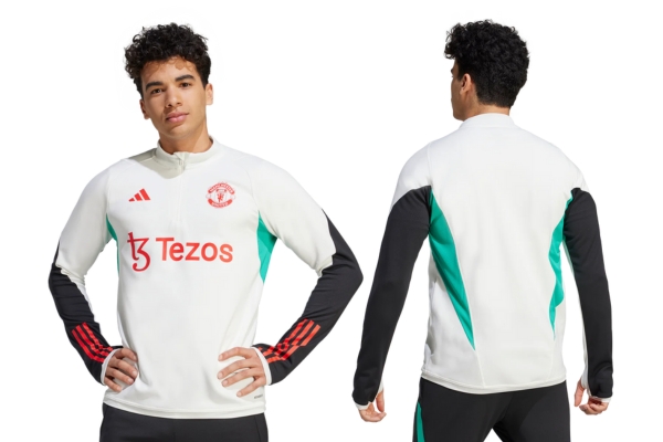 Jaqueta de Treino Adidas Manchester United 2023-2024 Branca, com logos vermelhos, detalhes verdes e aplicações pretas, inspirada no modelo Adidas Tiro 23. Ideal para torcedores que buscam estilo e conforto durante os treinos.