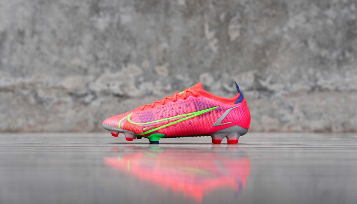 Chuteira Nike Mercurial Vapor 14 Elite FG Spectrum em cores vibrantes, com design leve e minimalista. A chuteira possui um colarinho Flyknit para suporte adaptável, placa Nike Aerotrak com ranhuras em forma de chevron para aceleração explosiva e tração multidirecional, e tecnologia NikeGrip na parte interna do calcanhar para ajuste firme. 