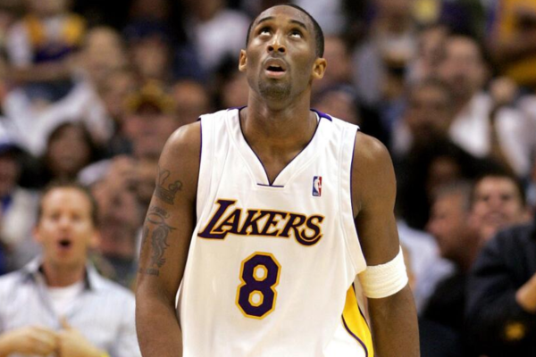 Los Angeles Lakers da temporada 2002-2006, modelo alternativo nas cores branco, amarelo e azul. A peça exibe o logo oficial dos Lakers e os números de Kobe Bryant e Shaquille O'Neal, celebrando a dinastia de campeões daquela época.