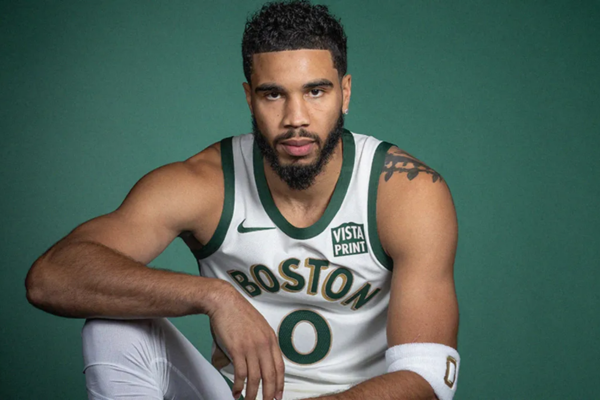 Regata City Edition Boston Celtics Nike 2023/24 em branco, verde e marrom, destacando elementos históricos, como a fita tecida que remete às cestas artesanais de pêssego. Uma homenagem à tradição do Celtics | Tevo Sports