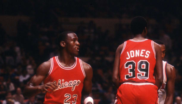 Regata Reserva dos Chicago Bulls da temporada de 1984-1985, a temporada de estreia de Michael Jordan na NBA. A peça apresenta as cores clássicas da equipe - vermelho, preto e branco - e o logo dos Bulls. 