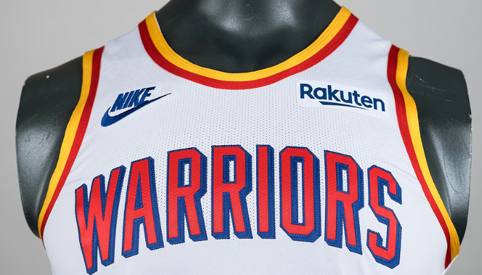 Regata classic edition do Golden State Warriors da temporada 2024-2025, modelo clássico da Nike. A camisa branca apresenta detalhes em azul, vermelho e amarelo, com a inscrição "Warriors" em destaque.